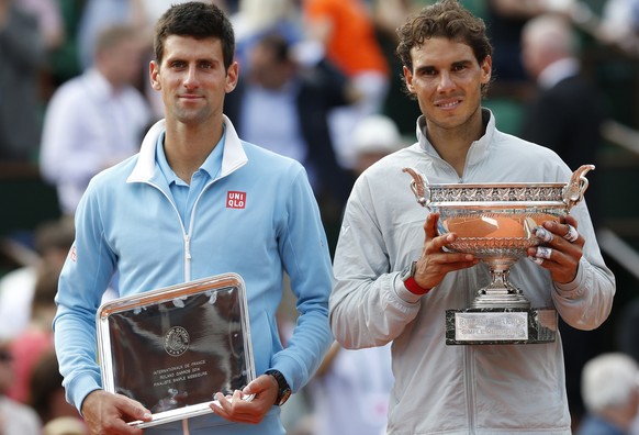 Spain&#039;s Rafael Nadal, right, holds the trophy after winning the final of the French Open tennis tournament against Serbia&#039;s Novak Djokovic, left, at the Roland Garros stadium, in Paris, Fran ...