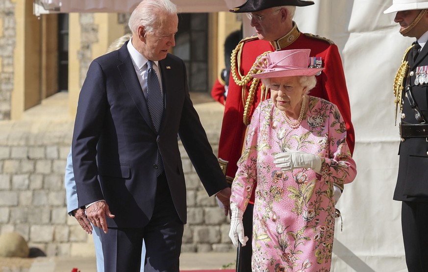 Britain&#039;s Queen Elizabeth II, right, walks with US President Joe Biden during his visit to Windsor Castle, near London, Sunday June 13, 2021. (Chris Jackson/Pool Photo via AP)