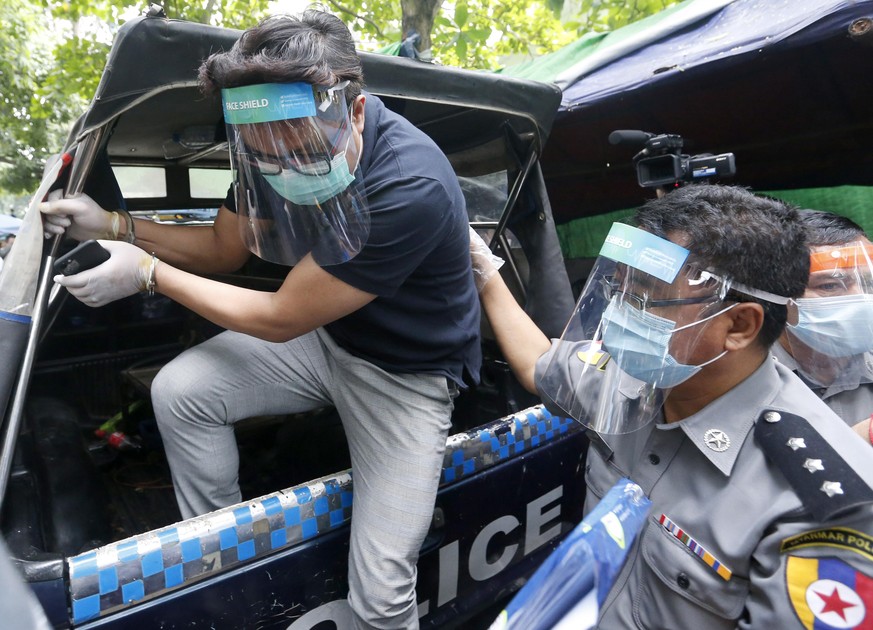 epa08432911 Canadian pastor David Lah (L) is escorted by police as he arrives at the Mayangone township court in Yangon, Myanmar, 20 May 2020. Myanmar-born pastor David Lah was charged with defying co ...