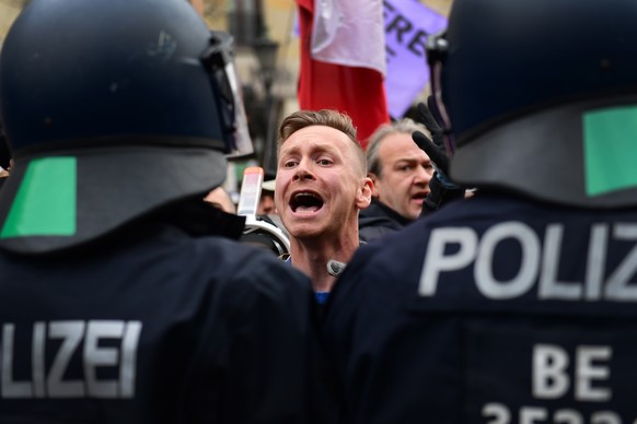 epa08826883 A protester shouts at police officers during a demonstration against German coronavirus restrictions, in Berlin, Germany, 18 November 2020. While German interior minister prohibited demons ...