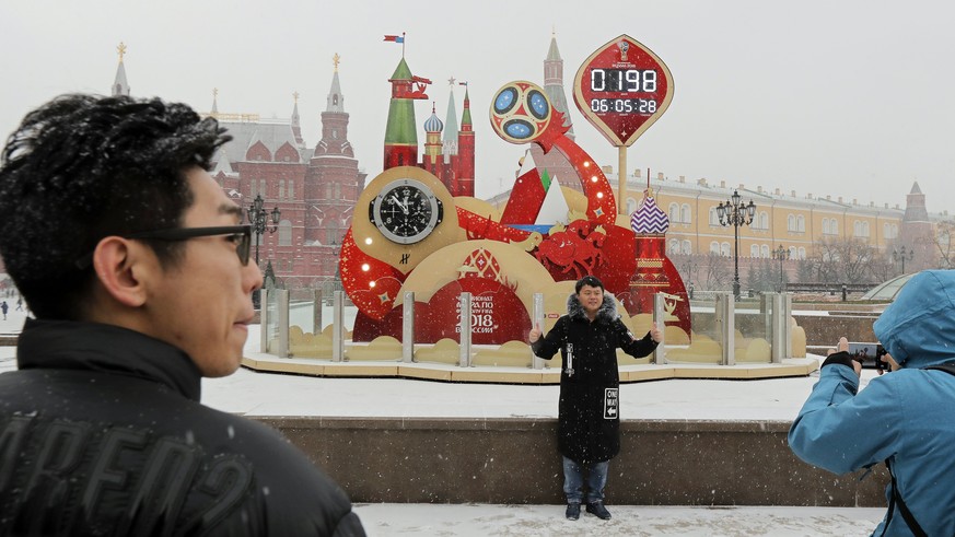 epa06355352 Chinese tourists pose in front of a clock counting down to the opening match of the FIFA World Cup 2018 on Manezhnaya Square in front of Moscow Kremlin in Moscow, Russia, 28 November 2017. ...