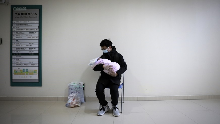 A man holds his newborn baby in hospital during the peak of the COVID-19 outbreak in Wuhan, China in a scene from the documentary &quot;76 Days.&quot; The film, shot in four Wuhan hospitals, captures  ...