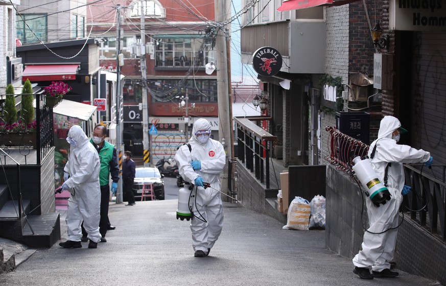 epa08416735 Volunteers spray disinfectant along a street in the popular tourist district of Itaewon in Seoul, South Korea, 12 May 2020. According to reports, more than 100 new coronavirus cases have b ...