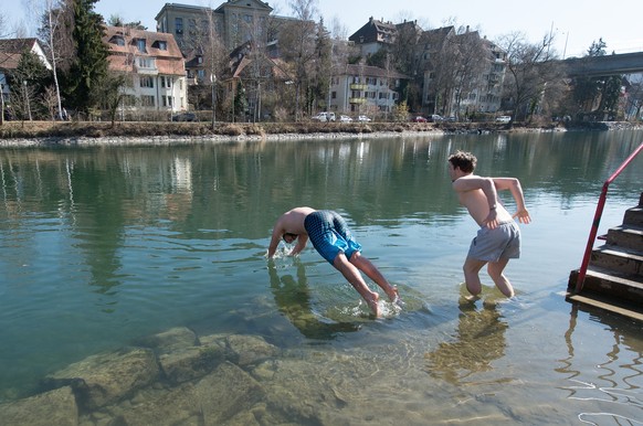Davide und David tauchen an einem 20 Grad warmen Fruehlingstag in die sieben Grad kalten Aare am Sonntag, 16. Maerz 2014, im Marzili in Bern. (KEYSTONE/Lukas Lehmann)