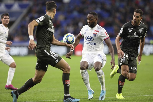 Lyon&#039;s Moussa Dembele, center, challenges for the ball with Dijon&#039;s Nayef Aguerd, left, and Wesley Lautoa, right, during the French League 1 soccer match between Lyon and Dijon, at the Stade ...