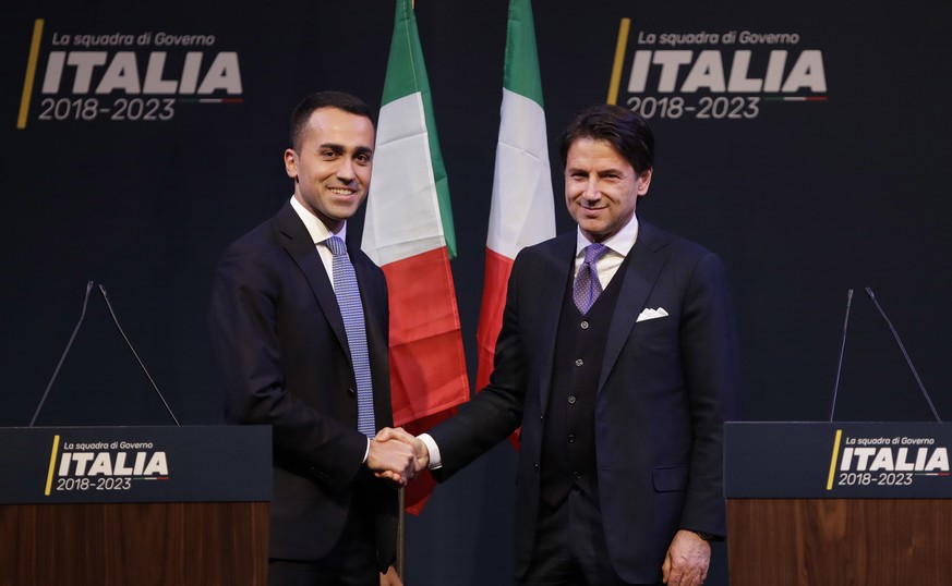 In this photo taken on Thursday, March 1, 2018, Giuseppe Conte, right, shakes hands with leader of the Five-Star Movement, Luigi Di Maio, during a meeting in Rome. Italy edged toward its first populis ...
