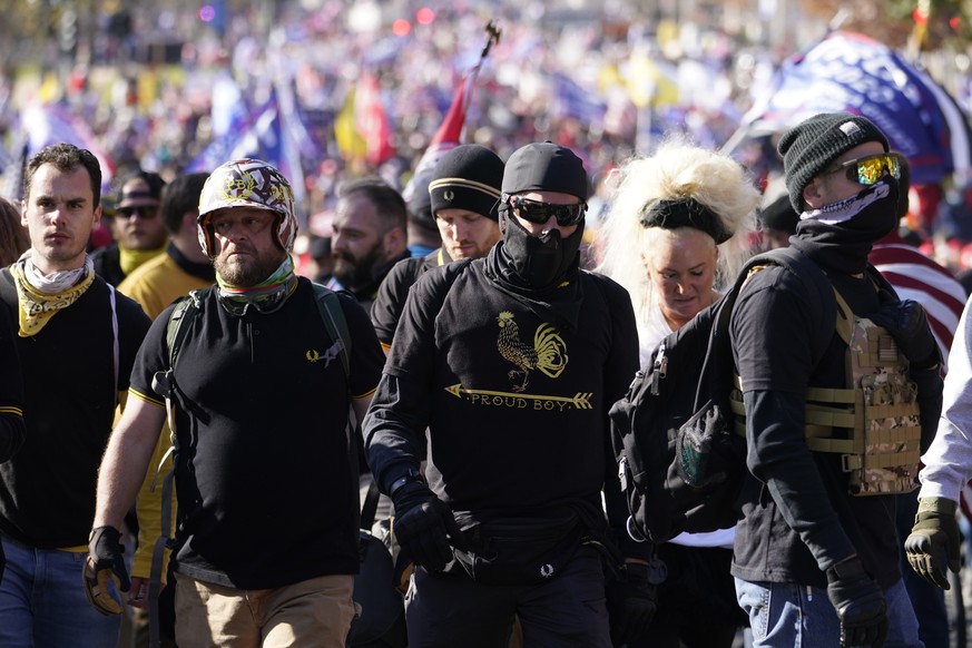 People wearing shirts with Proud Boys on them join supporters of President Donald Trump in a march Saturday Nov. 14, 2020, in Washington. (AP Photo/Jacquelyn Martin)