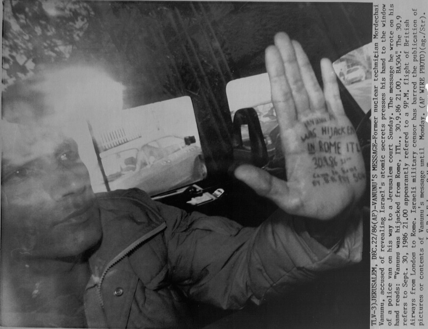 Former nuclear technician Mordechai Vanunu, accused of revealing Israel&#039;s atomic secrets, presses his hand to the window of a police van on his way to a Jerusalem court Sunday, Decemver 22, 1987. ...