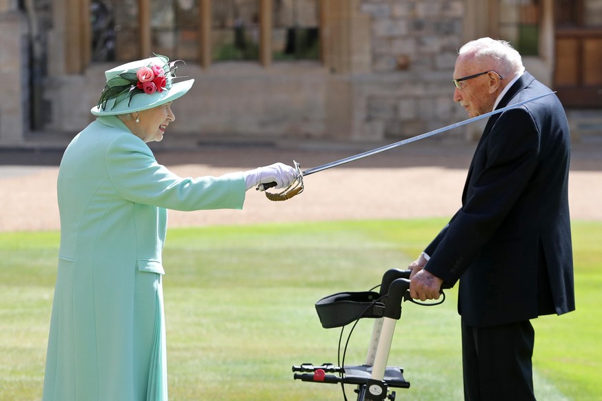WINDSOR, ENGLAND - JULY 17: Queen Elizabeth II awards Captain Sir Thomas Moore with the insignia of Knight Bachelor at Windsor Castle on July 17, 2020 in Windsor, England. British World War II veteran ...