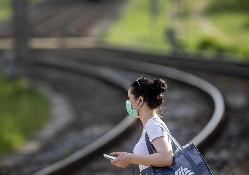 A woman wears a face mask as she goes to a bus stop in Frankfurt, Germany, Friday, May 8, 2020. To avoid the outspread of the coronavirus wearing a mask in busses and subway trains is mandatory. (AP P ...