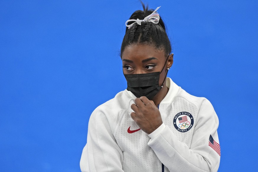Simone Biles, of the United States, stands wearing a mask after she exited the team final with apparent injury, at the 2020 Summer Olympics, Tuesday, July 27, 2021, in Tokyo. The 24-year-old reigning  ...