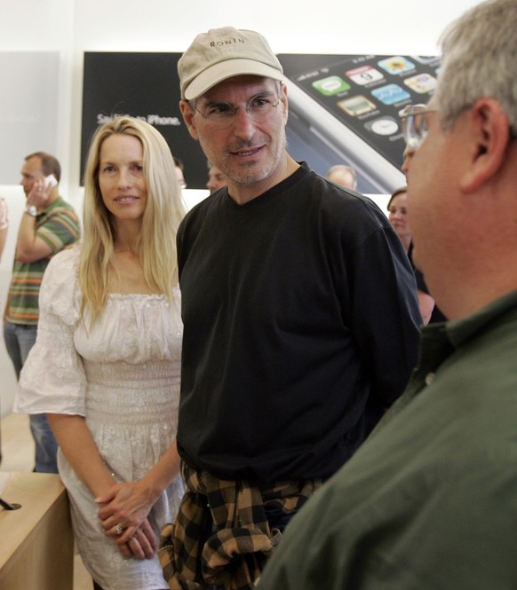 ** ADDS ID OF HIS WIFE ** Apple CEO Steve Jobs, center, and his wife Laurene Powell meet with customers after the launch of the new Apple iPhone in Palo Alto, Calif., Friday, June 29, 2007. (AP Photo/ ...