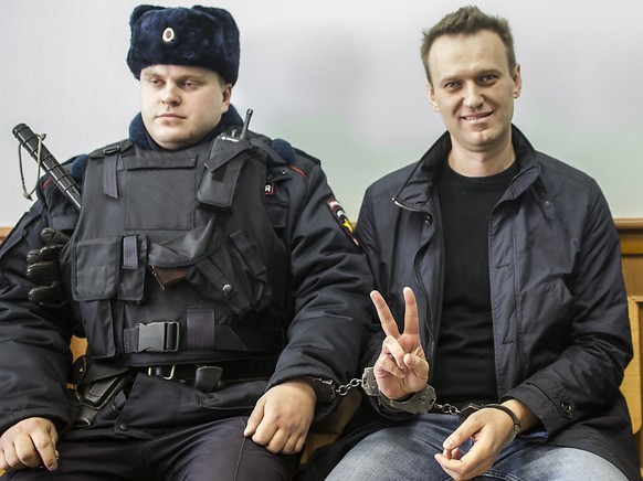 ARCHIV - Alexej Nawalny (r) zeigt ein Victory-Zeichen, w