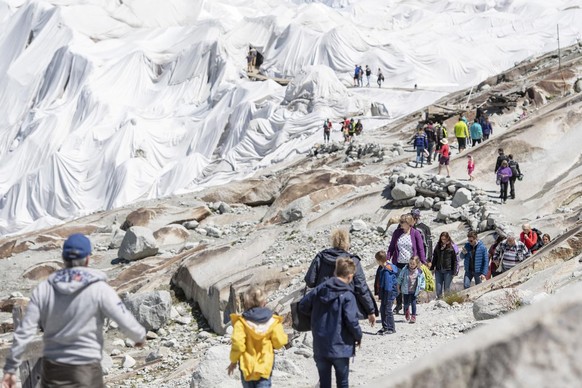 Touristen besuchen den Wanderweg und die mit Planen abgedeckte Eisgrotte am Gletscherende des Rhonegletscher oberhalb von Gletsch am Furkapass, am Samstag, 18. Juli 2020. (KEYSTONE/Urs Flueeler)