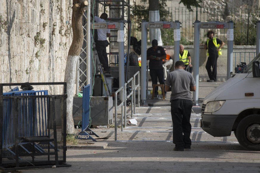 epa06107141 Israeli employees install a barrier next to the metal detectors outside Lions&#039; Gate, the main the entrance to the Al-Aqsa compound, as part of the security measures taken by the Israe ...