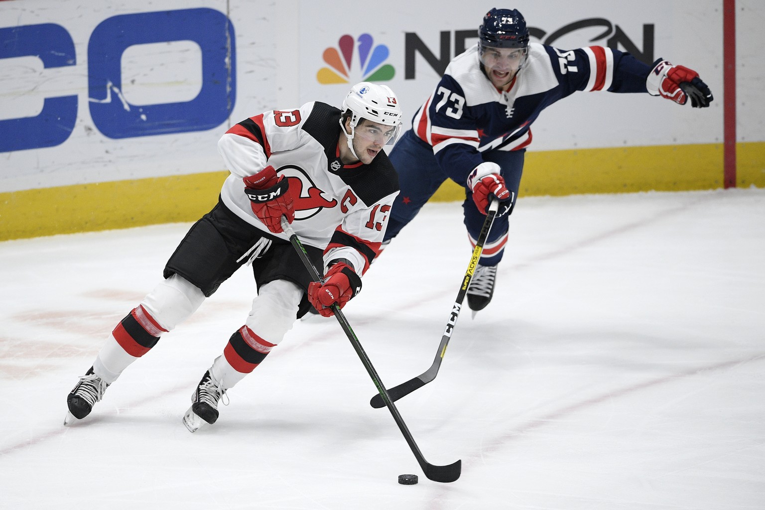 New Jersey Devils center Nico Hischier (13) skates with the puck in front of Washington Capitals left wing Conor Sheary (73) during the first period of an NHL hockey game, Sunday, Feb. 21, 2021, in Wa ...