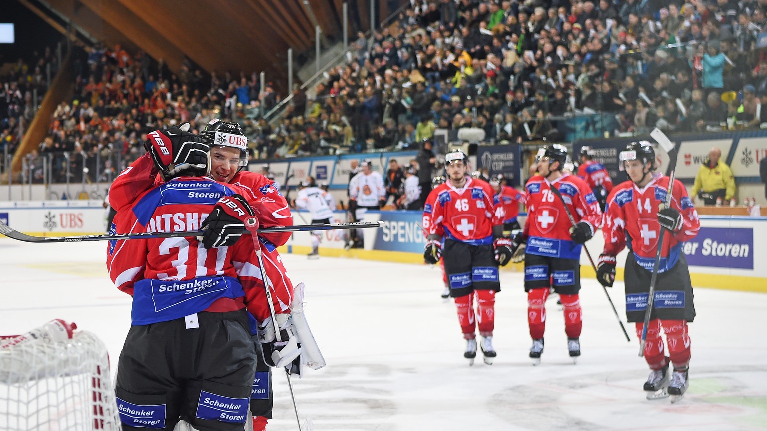 Team Suisse player Luca Boltshauser, Yannick Rathgeb and the team celebrate after the game between Team Suisse and Haemeenlinna PK at the 91th Spengler Cup ice hockey tournament in Davos, Switzerland, ...