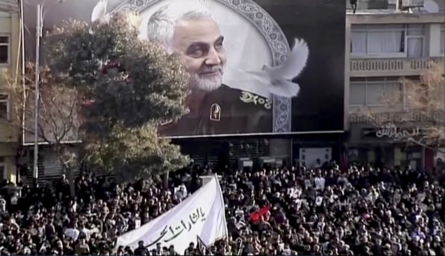 In this image made from a video, mourners gather to pay their respects to the slain Gen. Qassem Soleimani who was killed in a U.S. airstrike, in Kerman, Iran Tuesday, Jan. 7, 2020. (Iran Press via AP)