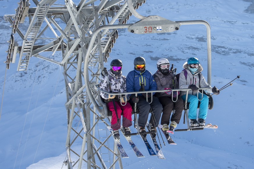 Skifahrer mit Schutzmaske auf dem Sessellift Lauberhorn aufgenommen am Freitag, 8. Januar 2021, im Skigebiet Grindelwald - Wengen. Die Berner Skigebiete bleiben trotz Coronavirus geoeffnet, mit reduzi ...