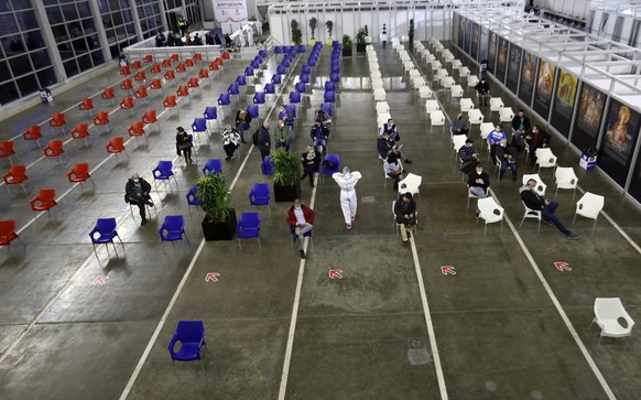 People sit, after receiving a COVID-19 vaccine at Belgrade Fair makeshift vaccination center, in Belgrade, Serbia, Monday, Jan. 25, 2021. Serbia were the first European country to receive the Chinese  ...