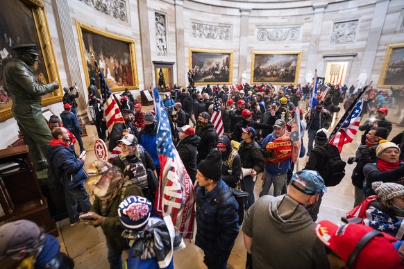 epa08926301 Supporters of US President Donald J. Trump and his baseless claims of voter fraud run through the Rotunda of the US Capitol after breaching Capitol security during their protest against Co ...