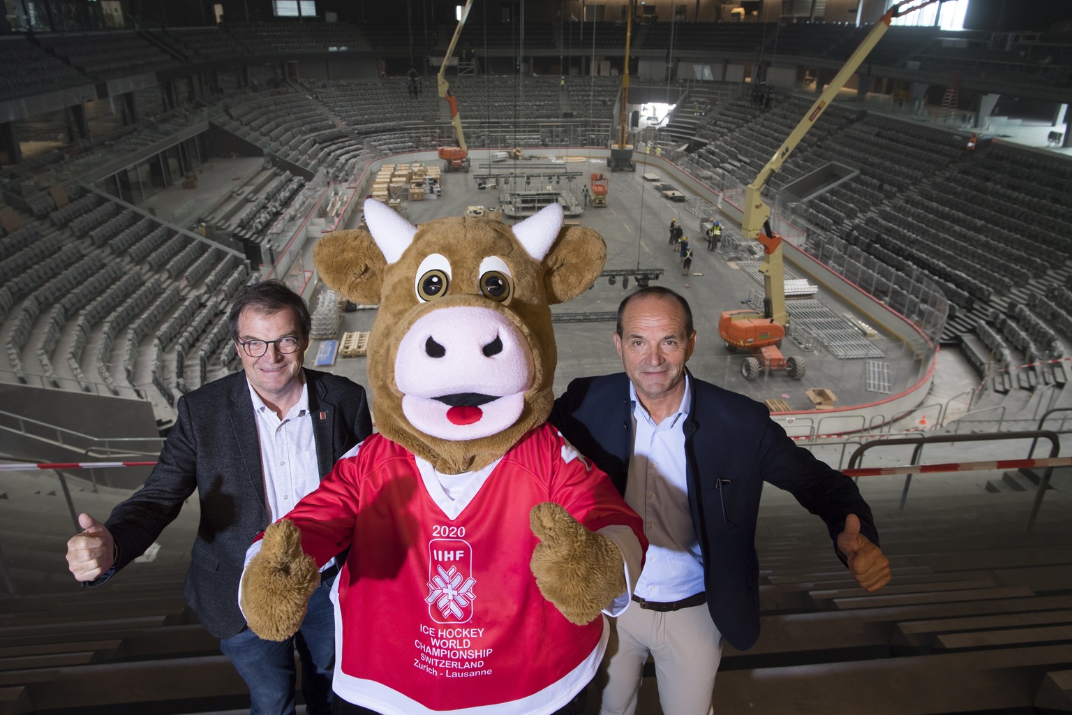 Gian Gilli, right, General Secretary of the 2020 IIHF Ice Hockey World Championship and Jean-Marie Viaccoz, left, President of the 2020 IIHF Ice Hockey World Championship pose with Cooly, the official ...