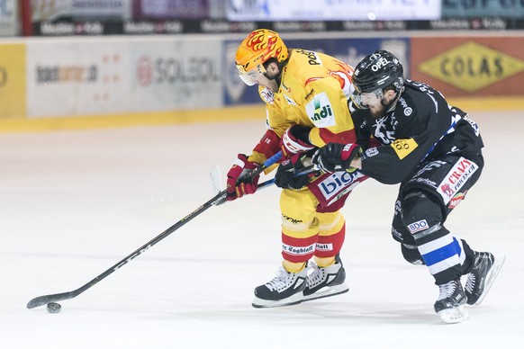 Le Top Scorer biennois Marc-Antoine Pouliot, gauche, lutte pour le puck avec le defenseur fribourgeois Andrea Glauser, droite, lors du match du championnat suisse de hockey sur glace de National Leagu ...