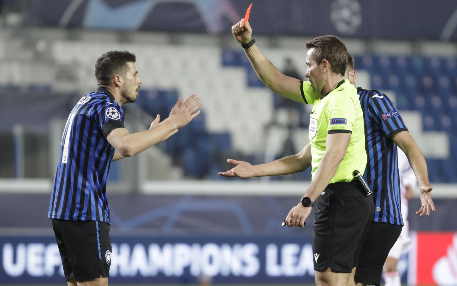 Referee Tobias Stieler, right, shows a red card to Atalanta&#039;s Remo Freuler during the Champions League, round of 16, first leg soccer match between Atalanta and Real Madrid, at the Gewiss Stadium ...