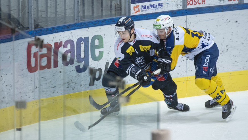 Ambri&#039;s player Giacomo Dal Pian and Davos&#039; player Lorenz Kienzle, from left, fight for the puck, during the preliminary round game of National League Swiss Championship between HC Ambri-Piot ...