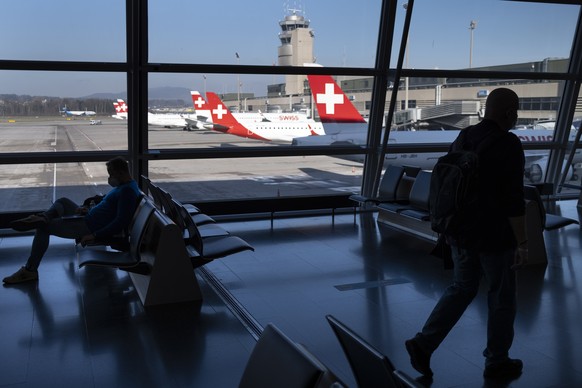 epa09091912 Passengers wearing face masks wait before boarding in an airplane in front of parked Swiss International Air Lines airplanes at the Zuerich Airport (Flughafen Zuerich) amid the coronavirus ...