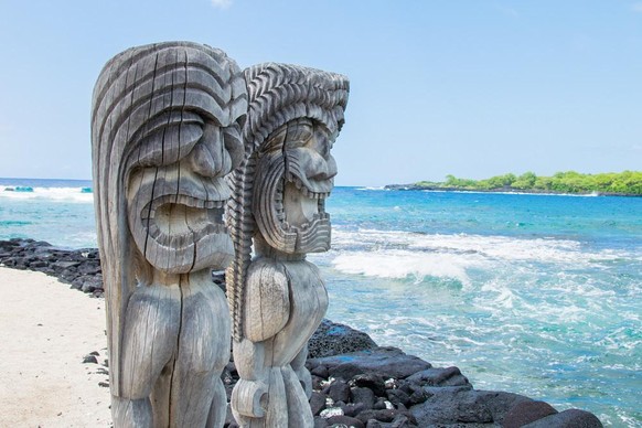 Dein Gesicht, wenn du merkst, dass du dich auf Gaggi erholst – illustriert anhand polynesischer Holzschnitzereien im Ki'i Pu'uhonua O Honaunau Nationalpark.