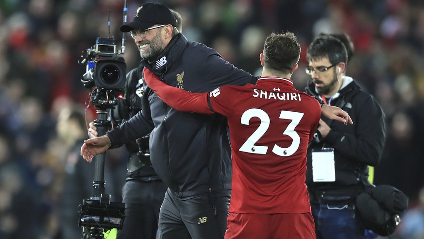 Liverpool manager Jurgen Klopp, left, celebrates with Xherdan Shaqiri after winning the game against Arsenal, during their English Premier League soccer match at Anfield Stadium in Liverpool, England, ...