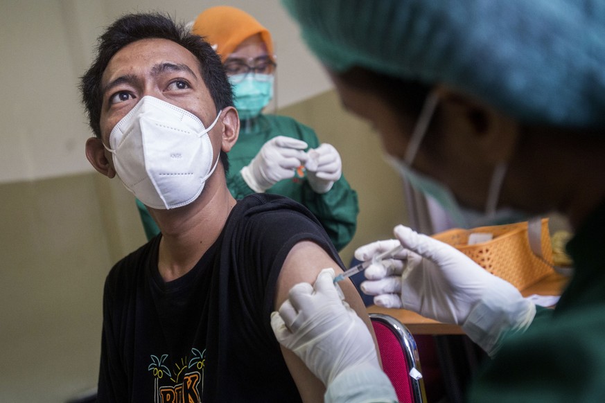 A nurse gives a shot of a COVID-19 vaccine to a colleague at a hospital in Medan, North Sumatra, Indonesia, Monday, Jan. 25, 2021. The world&#039;s fourth most populous country has started giving COVI ...