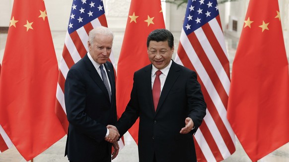 FILE - In this Dec. 4, 2013, file photo, Chinese President Xi Jinping, right, shakes hands with then U.S. Vice President Joe Biden as they pose for photos at the Great Hall of the People in Beijing. A ...