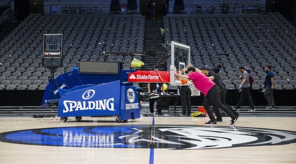 Crews remove a basketball hoop from the court after the Dallas Mavericks defeated the Denver Nuggets in an NBA basketball game on Wednesday, March 11, 2020 at American Airlines Center in Dallas. The N ...