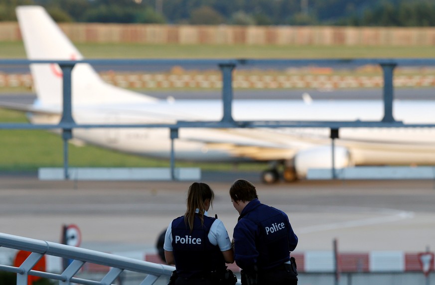 Belgian police officers patrol as a plane lands at Zaventem international airport near Brussels, Belgium, August 10, 2016. REUTERS/Francois Lenoir