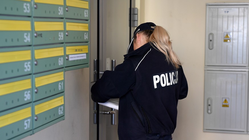 epa08326022 A Police officer checks on people placed in quarantine, during the coronavirus pandemic in Jaroslaw, southeastern Poland, 27 March 2020. The number of confirmed coronavirus cases in Poland ...