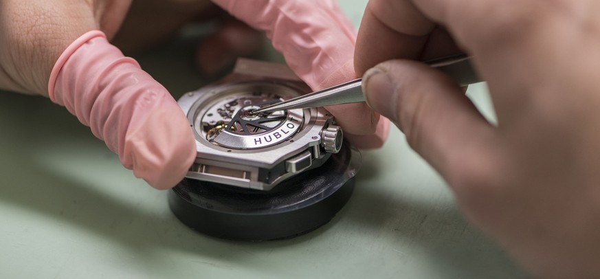 A watchmaker makes a watch, pictured at Swiss luxury watches manufacturer Hublot in Nyon, canton of Vaud, Switzerland, on March 6, 2014. (KEYSTONE/Christian Beutler)

Ein Uhrmacher baut eine Uhr zusam ...