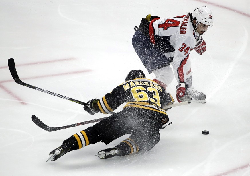 Boston Bruins left wing Brad Marchand (63) is dumped to the ice by Washington Capitals defenseman Jonas Siegenthaler (34) near the Capitals&#039; goal during the first period of an NHL hockey game Thu ...