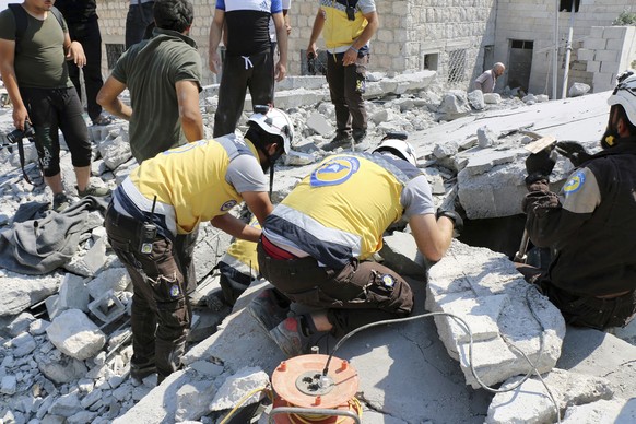 This photo provided by the Syrian Civil Defense White Helmets, which has been authenticated based on its contents and other AP reporting, shows Syrian White Helmet civil defense workers search for vic ...