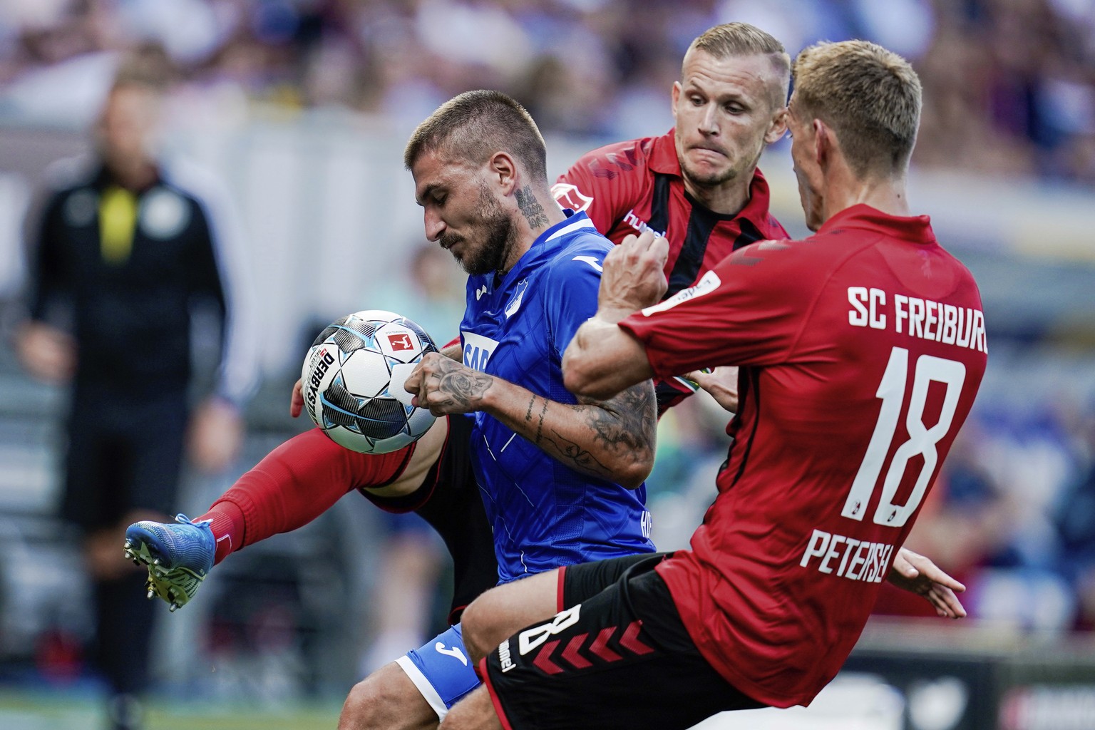 From left, Hoffenheim&#039;s Konstantinos Stafylidis challenges for the ball with Freiburg&#039;s Jonathan Schmid and Nils Petersen during the German Bundesliga soccer match between TSG 1899 Hoffenhei ...