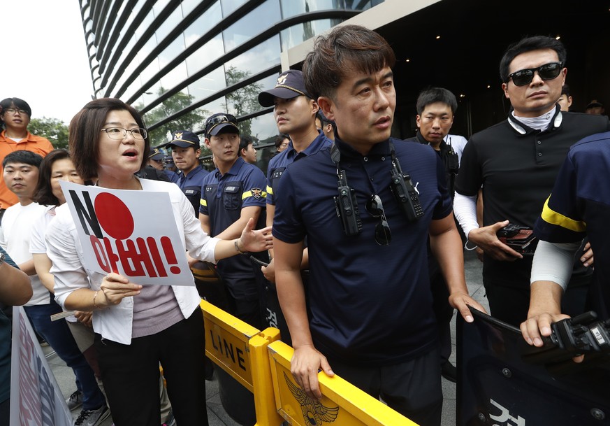 A South Korean protester argues with police officers during a rally against Japan in front of a building which houses Japanese embassy in Seoul, South Korea, Friday, Aug. 2, 2019. Japan&#039;s Cabinet ...