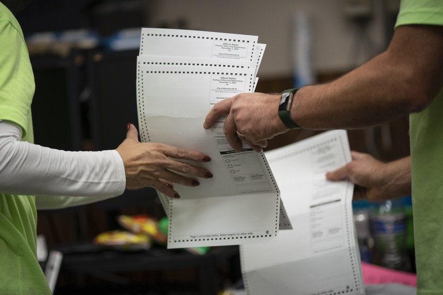 Poll workers sort out early and absentee ballots at the Kenosha Municipal building on Election Day, late Tuesday, Nov. 3, 2020, in Kenosha, Wis. (AP Photo/Wong Maye-E)