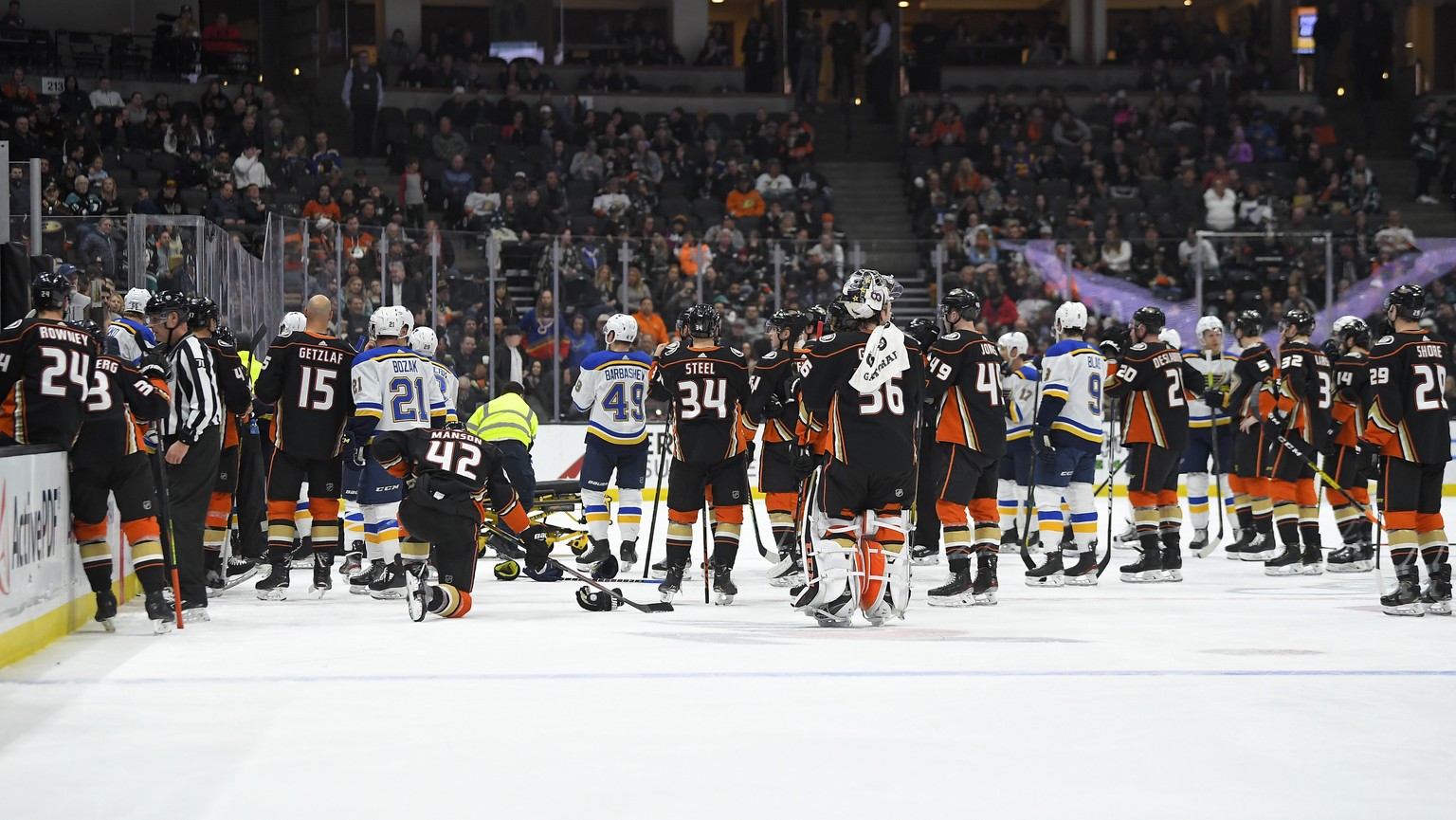 Members of the St. Louis Blues and Anaheim Ducks gather on the ice as Blues defenseman Jay Bouwmeester, who suffered a medical emergency, is worked on by medical personnel during the first period of a ...
