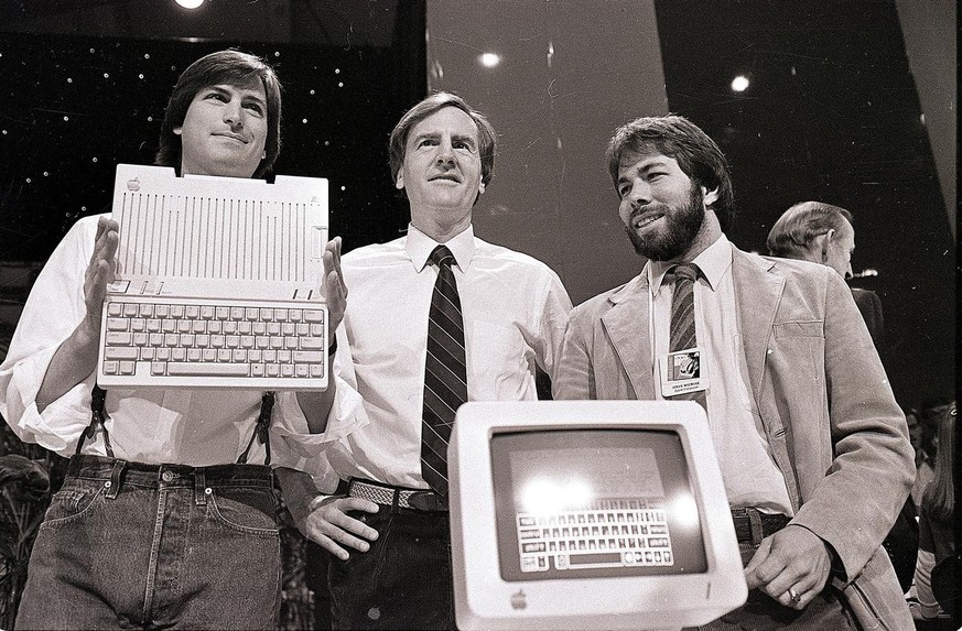 In this April 24, 1984 photo, Steve Jobs, left, chairman of Apple Computers, John Sculley, center, then president and CEO, and Steve Wozniak, co-founder of Apple, unveil the new Apple IIc computer in  ...