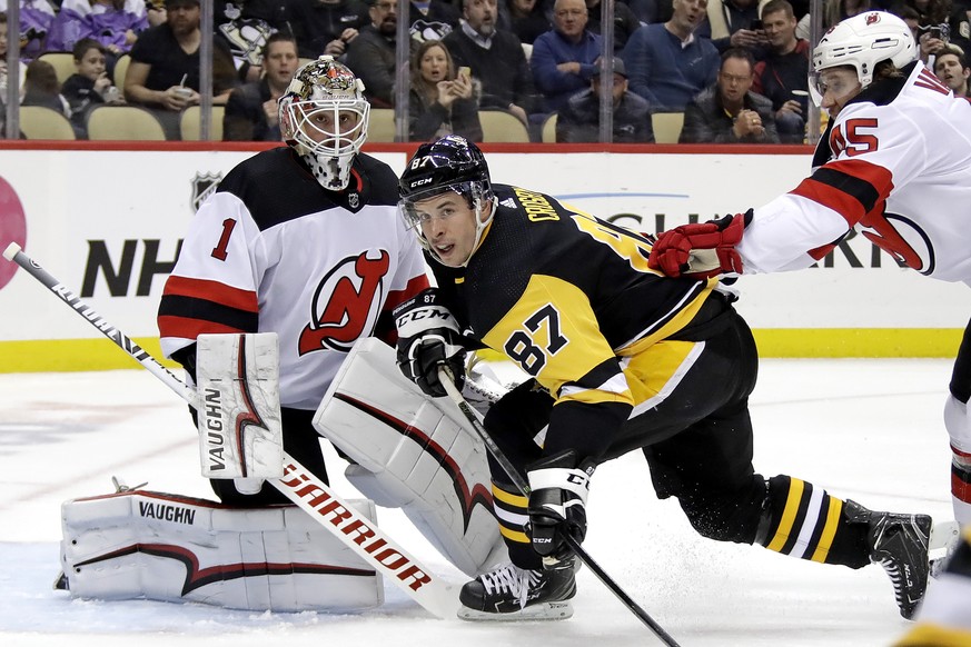 New Jersey Devils&#039; Sami Vatanen (45) checks Pittsburgh Penguins&#039; Sidney Crosby (87) in front of goalie Keith Kinkaid (1) during the second period of an NHL hockey game in Pittsburgh, Monday, ...