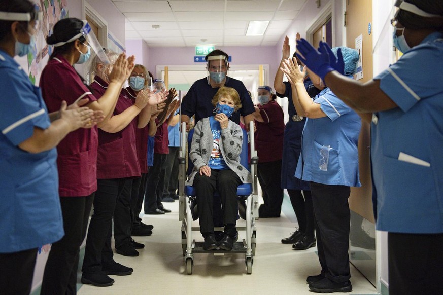 Margaret Keenan, 90, is applauded by staff as she returns to her ward after becoming the first patient in the UK to receive the Pfizer-BioNTech COVID-19 vaccine, at University Hospital, Coventry, Engl ...