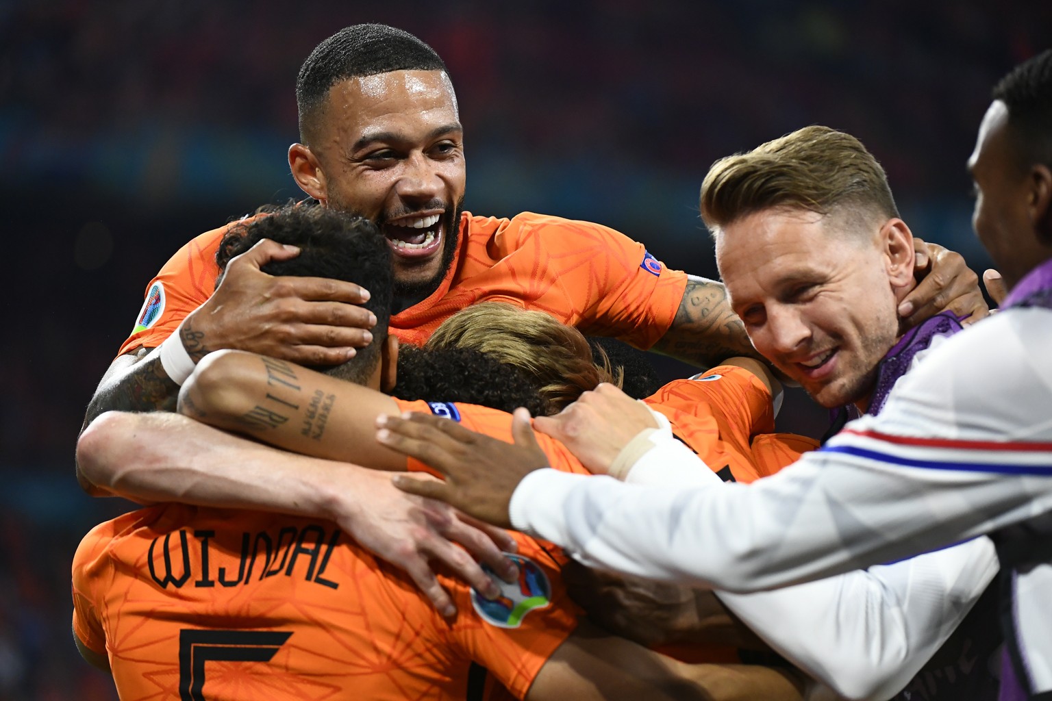 epa09281205 Memphis Depay (L, top) of the Netherlands celebrates with teammates during the UEFA EURO 2020 preliminary round group C soccer match between the Netherlands and Austria in Amsterdam, Nethe ...