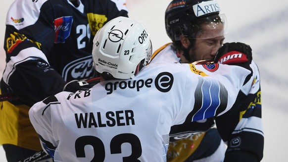 Fribourg&#039;s player Samuel Walser, left, and Ambri&#039;s player Tommaso Goi, right, during the preliminary round game of National League Swiss Championship 2018/19 between HC Ambri Piotta and HC F ...