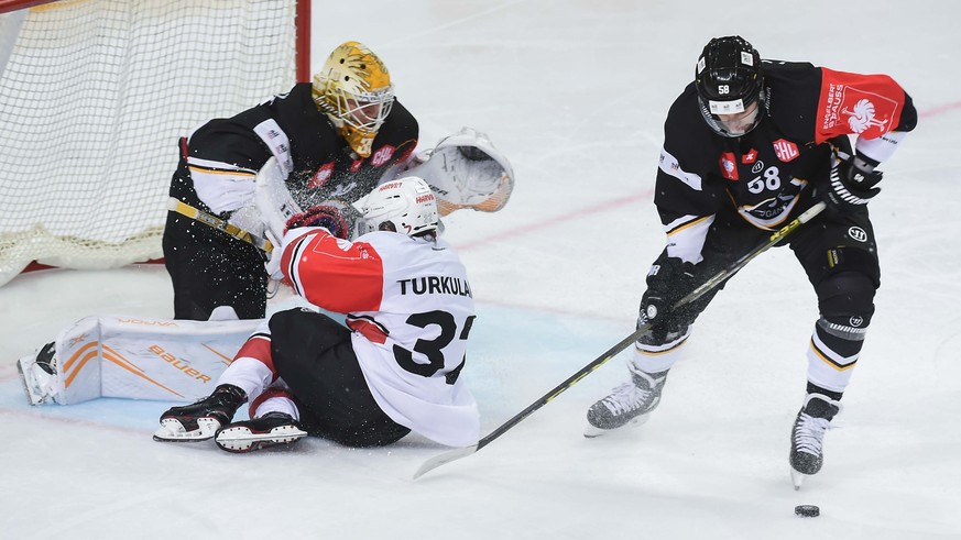 Luganos Goalkeeper Elvis Merzlikins, left, and Roman Loeffel, right, are fighting for the puck with JYP Jerry Turkulainen, middle, during the Champions Hockey League match between Switzerland&#039;s H ...
